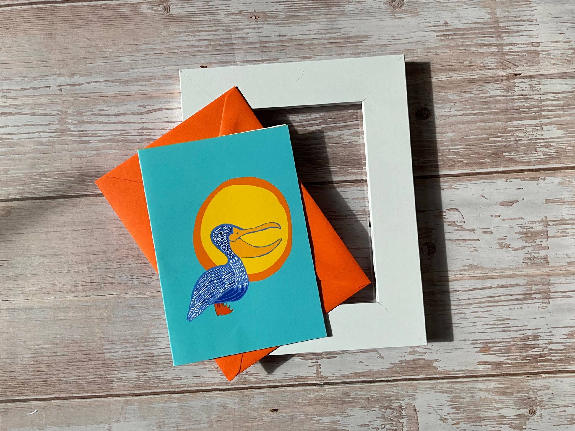 Pelican greetings card with orange envelope and a white picture frame