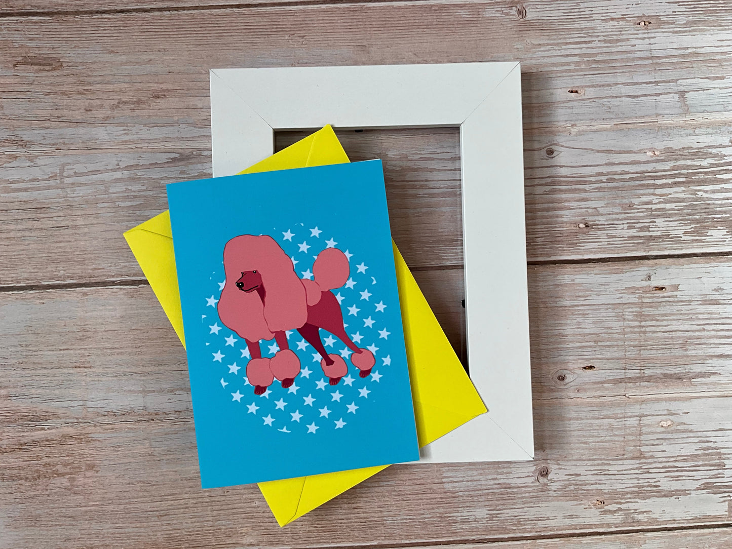 Card with a poodle design on a wooden surface