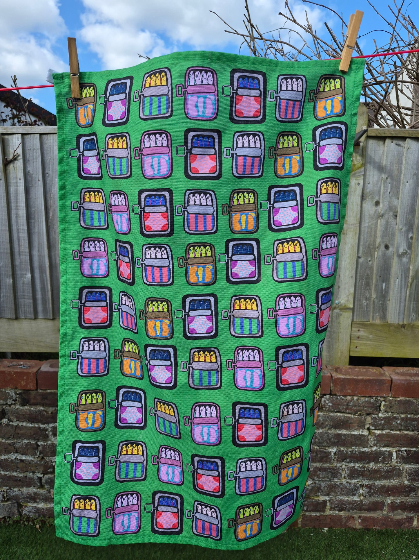 Green mackerel print tea towel on washing line