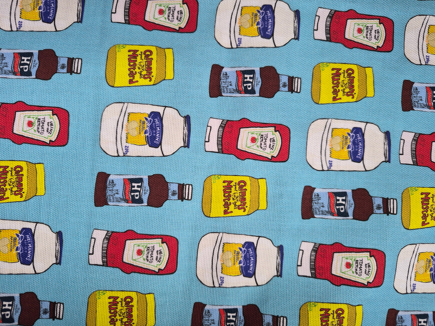 Close up of patterned blue tea towel with hand drawn condiments print 
