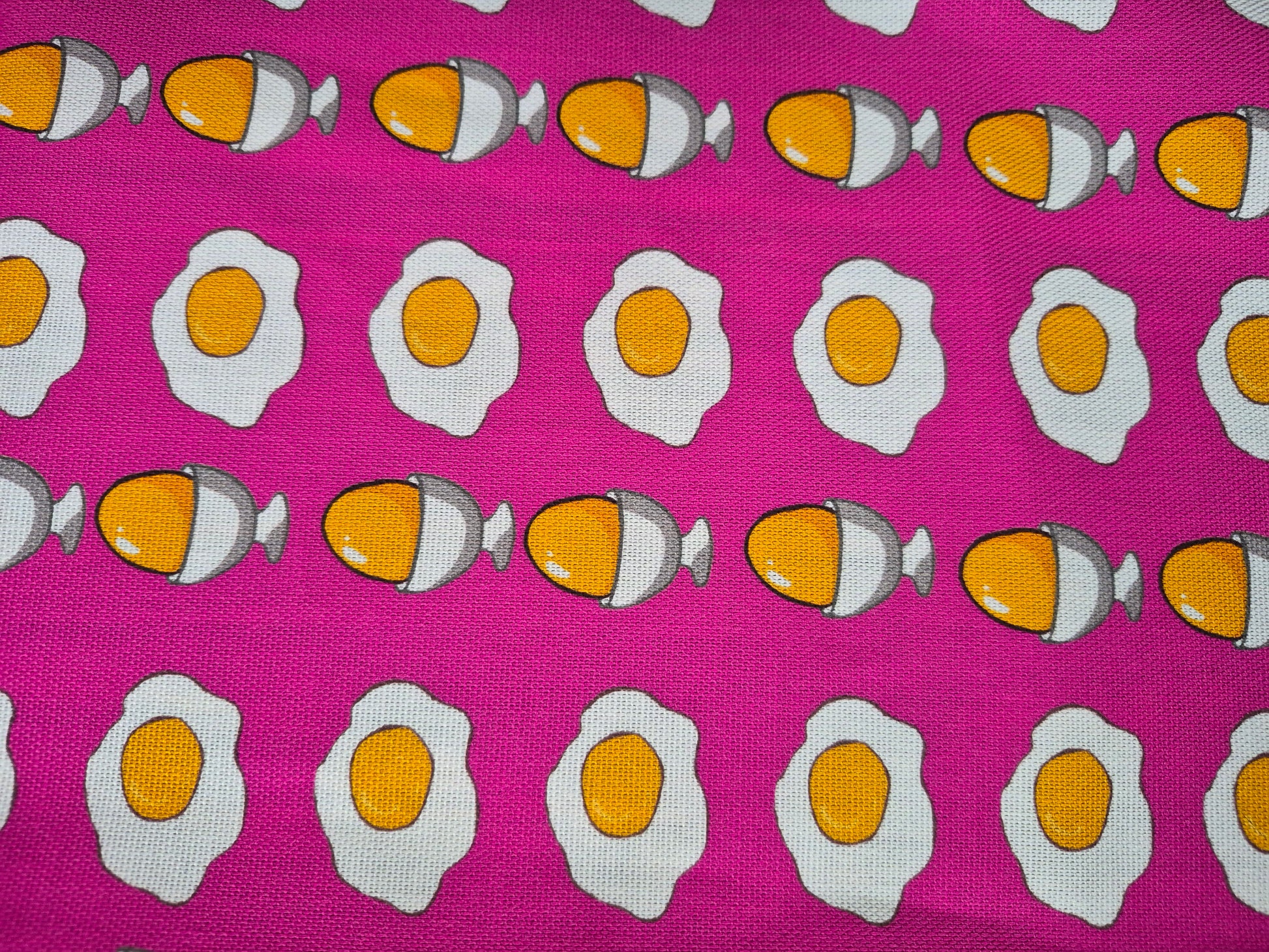 close up of egg pattern on a pink tea towel