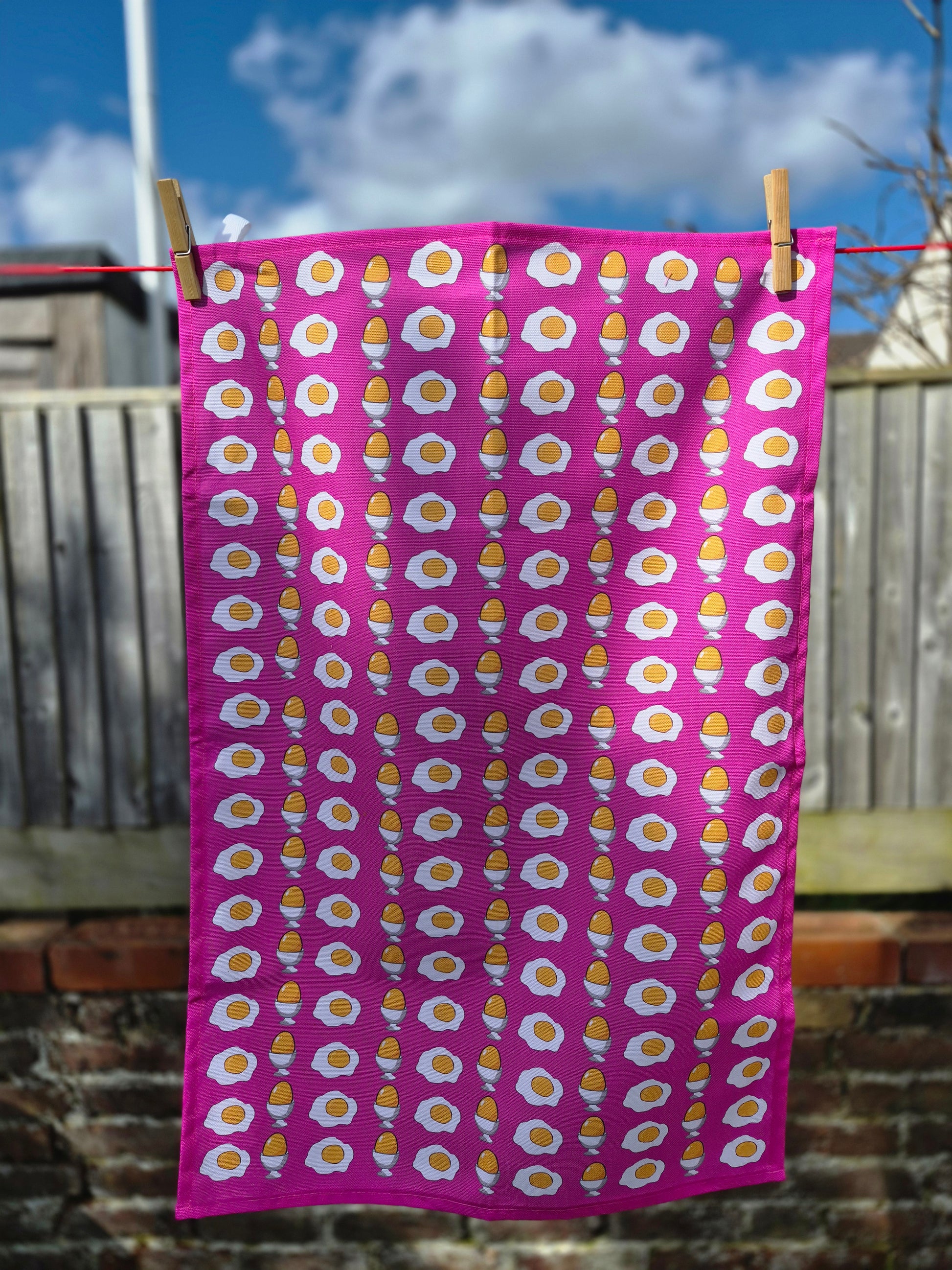 Pink printed tea towel with egg pattern