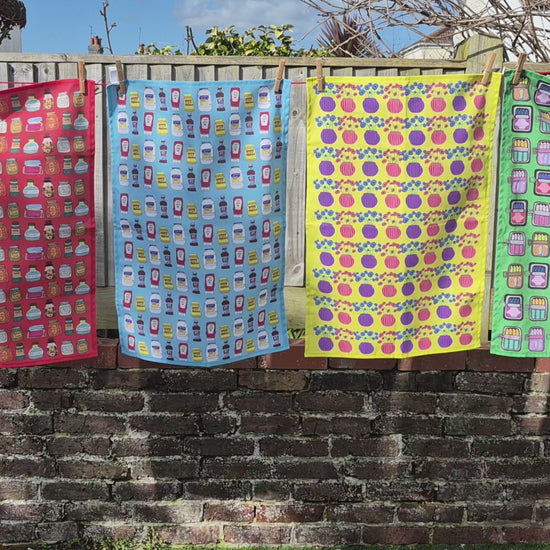 Colourful patterned tea towels hanging on a washing line