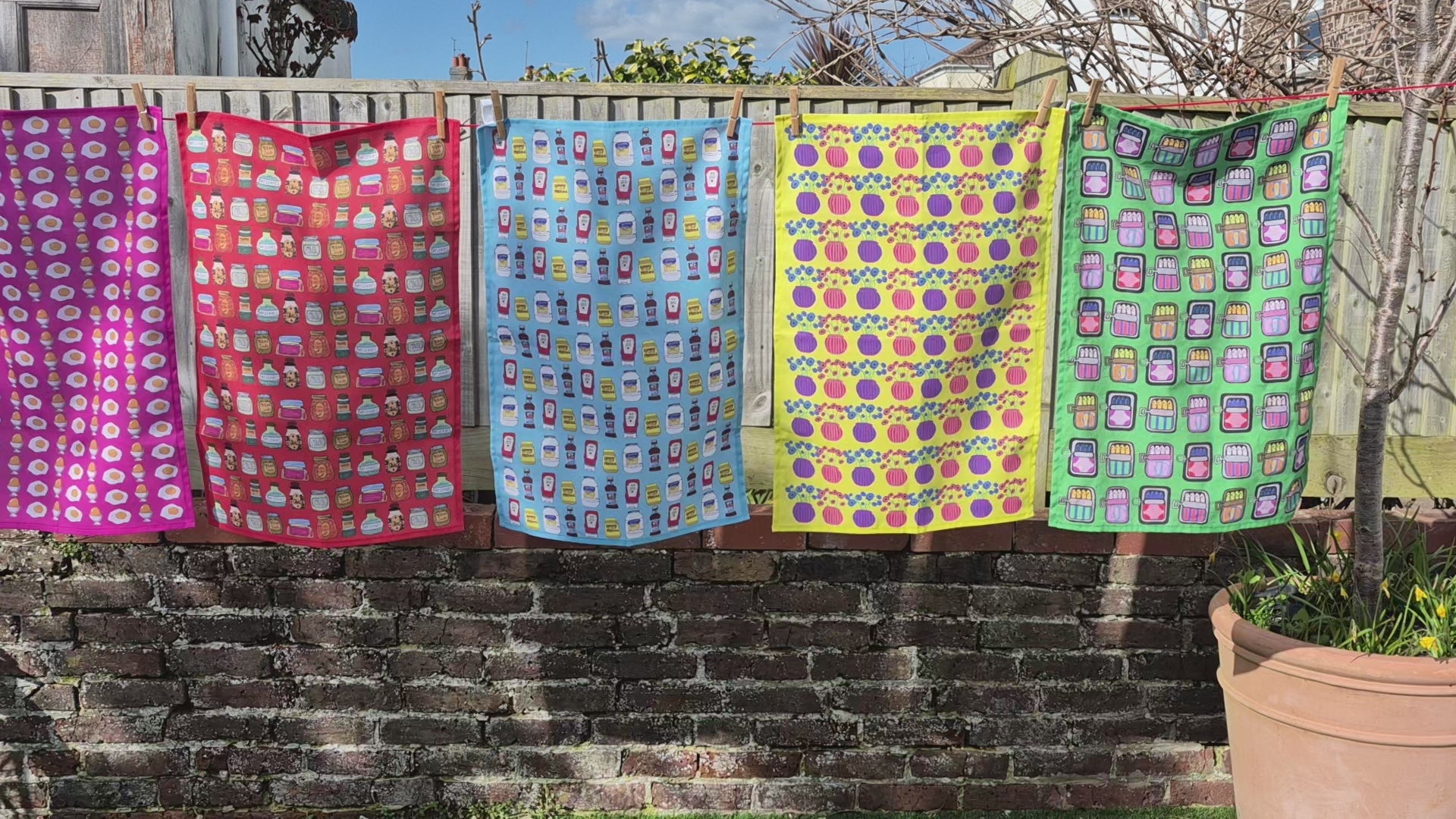 Colourful patterned tea towels hanging on a washing line