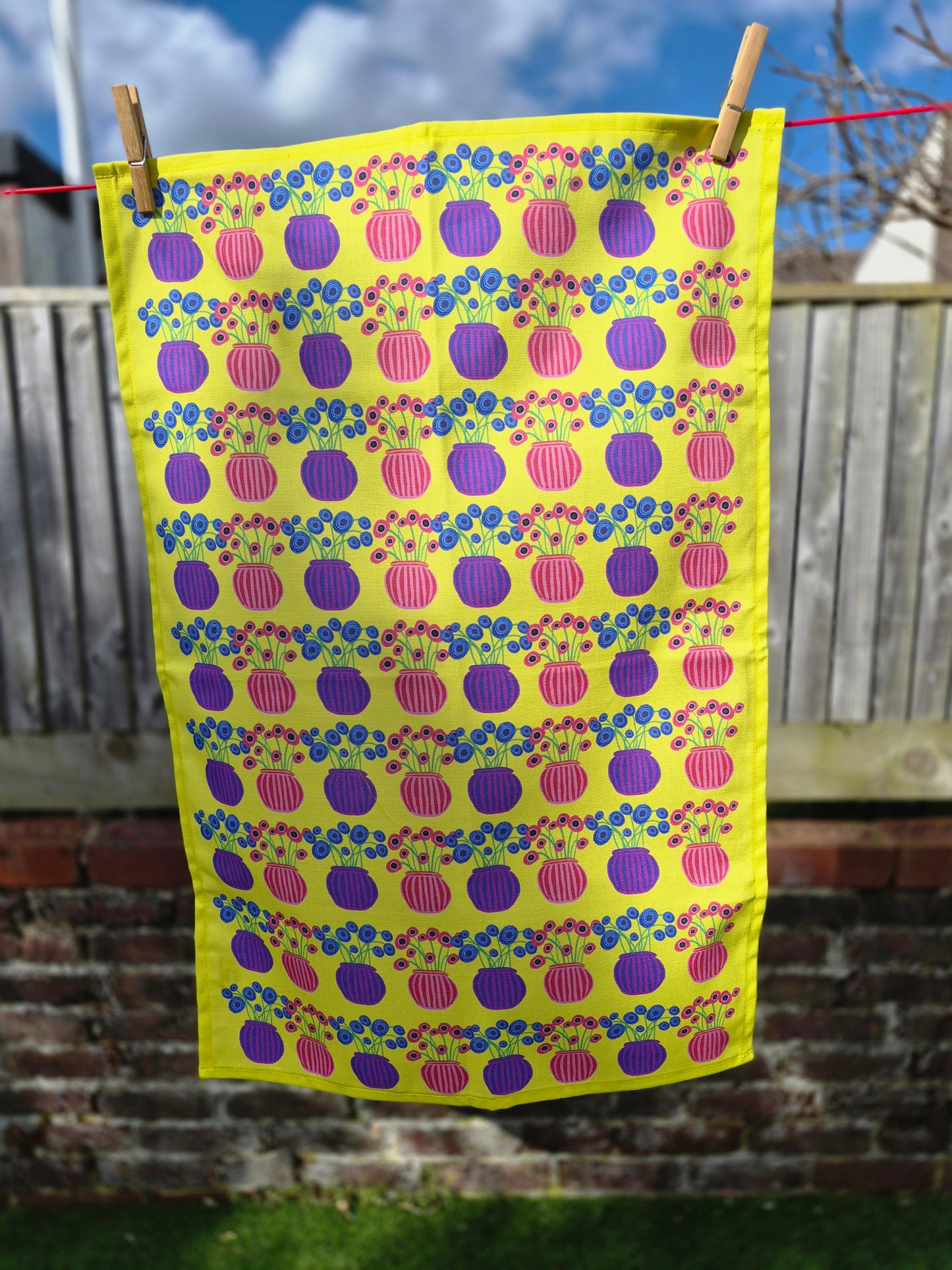 Yellow flower vase tea towel hanging on a washing line